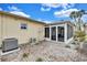 Backyard with an enclosed sunroom featuring an AC unit and low-maintenance stone ground cover at 111 Whispering Sands Cir # V38, Sarasota, FL 34242