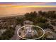 Sunset aerial view of beach home with pool and rooftop deck encircled by mature landscaping at 112 50Th St, Holmes Beach, FL 34217
