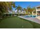 Beautiful backyard featuring a putting green, swimming pool, spa, patio and lush tropical landscaping at 112 50Th St, Holmes Beach, FL 34217