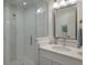 Bright bathroom with glass shower, mosaic tile accents, and white vanity with a decorative mirror at 112 50Th St, Holmes Beach, FL 34217