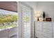 Light-filled bedroom displaying a dresser, decorative lamp, and glass balcony doors at 112 50Th St, Holmes Beach, FL 34217