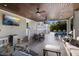 Open-air patio with covered seating, dining area, TV and views of pool area at 112 50Th St, Holmes Beach, FL 34217