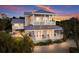 Elegant multi-story home with multiple balconies, showcasing its stunning architectural design at sunset at 112 50Th St, Holmes Beach, FL 34217
