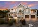 Exterior shot of home with brick paver driveway, lush landscaping, and balconies at 112 50Th St, Holmes Beach, FL 34217