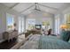 Bright main bedroom features high ceilings, natural light, and a cozy seating area with a balcony view at 112 50Th St, Holmes Beach, FL 34217