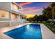 Stunning backyard oasis with a sparkling pool and spa, perfect for relaxation and outdoor entertainment at sunset at 112 50Th St, Holmes Beach, FL 34217