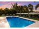 Luxurious backyard pool with lounge chairs, surrounded by lush landscaping, creating a private retreat for relaxation at 112 50Th St, Holmes Beach, FL 34217