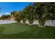Backyard putting green with palm trees and white privacy fence, perfect for the golf enthusiast at 112 50Th St, Holmes Beach, FL 34217