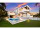 Rear exterior view showcasing a pool, hot tub, outdoor kitchen, and putting green at 112 50Th St, Holmes Beach, FL 34217