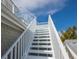 Exterior stairway with white railings offering access to upper levels on a beautiful day at 112 50Th St, Holmes Beach, FL 34217