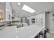 Contemporary kitchen featuring skylight, white cabinetry, stone backsplash, and stainless appliances at 1210 67Th Street E Ct, Bradenton, FL 34208