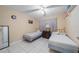 This bedroom is furnished with two twin beds, a dresser, a ceiling fan, and tile floors at 1224 Inverness St, Port Charlotte, FL 33952