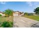 Charming single-story home features a light exterior, attached garage, and well-manicured lawn at 1224 Inverness St, Port Charlotte, FL 33952