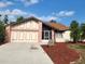 Charming single Gathering home with a two-car garage, well-manicured lawn, and mature landscaping at 1224 Inverness St, Port Charlotte, FL 33952