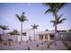 Modern home exterior featuring clean lines, white facade, stone walkway, and lush palm trees enhancing curb appeal at 1354 Westway Dr, Sarasota, FL 34236