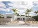 Striking modern home with palm trees, a concrete accent wall and minimalist front yard landscaping at 1354 Westway Dr, Sarasota, FL 34236