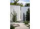 Zen garden featuring gravel, boulders, greenery, and a Buddha statue, framed by concrete walls and palm trees at 1354 Westway Dr, Sarasota, FL 34236