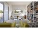 Well-lit living room with a bookshelf and large windows showcasing tropical greenery at 1354 Westway Dr, Sarasota, FL 34236