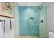 Beautiful walk-in shower with blue tiles, a built-in niche, and pebble flooring at 1354 Westway Dr, Sarasota, FL 34236