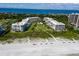 Aerial view of white condo buildings with beach access and community pool, showcasing luxurious beachfront living at 1485 Gulf Of Mexico Dr # 205, Longboat Key, FL 34228