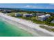 Expansive beach view, revealing white condo buildings, lush greenery, and a pristine shoreline at 1485 Gulf Of Mexico Dr # 205, Longboat Key, FL 34228