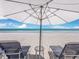 Beach scene with lounge chairs and umbrellas against the backdrop of the ocean at 1485 Gulf Of Mexico Dr # 205, Longboat Key, FL 34228