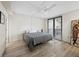Bright bedroom with hardwood floors, ceiling fan, and a large window offering natural light and an attached balcony at 1485 Gulf Of Mexico Dr # 205, Longboat Key, FL 34228