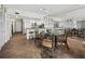 Open-concept dining area with a round table and chairs, adjacent to a modern kitchen with white cabinets and tile floors at 1485 Gulf Of Mexico Dr # 205, Longboat Key, FL 34228