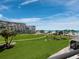 Scenic view from the condo overlooking a green lawn, sandy beach, and the ocean at 1485 Gulf Of Mexico Dr # 205, Longboat Key, FL 34228