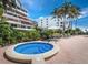 Community hot tub with palm trees and building in the background at 1485 Gulf Of Mexico Dr # 205, Longboat Key, FL 34228