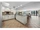 Open kitchen with island and modern appliances flows into the dining and living areas at 1485 Gulf Of Mexico Dr # 205, Longboat Key, FL 34228