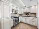 Well-lit kitchen features stainless steel appliances, granite countertops, and classic white cabinetry and tile backsplash at 1485 Gulf Of Mexico Dr # 205, Longboat Key, FL 34228