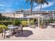Outdoor patio area with seating, a pergola, and lush landscaping near condos at 1485 Gulf Of Mexico Dr # 205, Longboat Key, FL 34228