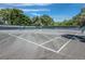 Well-maintained tennis court with nets, surrounded by trees, offering a private sports experience at 1485 Gulf Of Mexico Dr # 205, Longboat Key, FL 34228