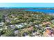 Expansive aerial view shows this property with mature trees surrounded by water and coastal cityscape at 1610 S Lake Shore Dr, Sarasota, FL 34231