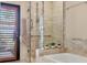 Close-up of a luxurious shower featuring marble walls, a glass door, and a convenient towel rack at 1610 S Lake Shore Dr, Sarasota, FL 34231