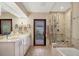 Modern bathroom featuring dual sinks, a glass-enclosed shower, and a view to the outdoor greenery at 1610 S Lake Shore Dr, Sarasota, FL 34231