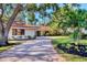Well-maintained single-story home featuring mature landscaping and a winding brick driveway at 1610 S Lake Shore Dr, Sarasota, FL 34231
