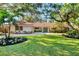 Inviting single-story home boasts lush landscaping, mature trees, and a circular driveway at 1610 S Lake Shore Dr, Sarasota, FL 34231