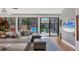 Bright living area featuring a gray sectional sofa and views of the outdoor patio and lush greenery at 1610 S Lake Shore Dr, Sarasota, FL 34231