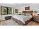 Cozy bedroom with hardwood floors, wooden furniture, and a large window offering natural light at 1610 S Lake Shore Dr, Sarasota, FL 34231