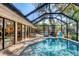 Enclosed pool featuring an outdoor dining area, multiple seating areas, and lush landscaping at 1610 S Lake Shore Dr, Sarasota, FL 34231