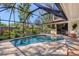 Inviting screened in pool area with beautiful stone tiling and outdoor seating at 1610 S Lake Shore Dr, Sarasota, FL 34231