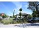 View of a single-Gathering home with mature trees, a chain-link fence, and an adjacent SUV at 1715 17Th W Ave, Bradenton, FL 34205