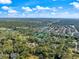 Aerial view of home with pool surrounded by lush trees and other homes, under blue sky, outlined in blue at 201 Eaglenook Way, Osprey, FL 34229