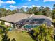 Aerial view of a home with a screened pool area surrounded by lush greenery and landscaping at 201 Eaglenook Way, Osprey, FL 34229