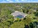 Aerial view of home featuring a screened-in pool surrounded by lush, mature landscaping at 201 Eaglenook Way, Osprey, FL 34229