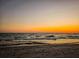 Peaceful beach view during a colorful sunset over the ocean with gentle waves at 201 Eaglenook Way, Osprey, FL 34229