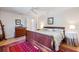 Bedroom with a wooden sleigh bed, red patterned rug, and bright natural light creates a relaxing atmosphere at 201 Eaglenook Way, Osprey, FL 34229