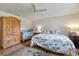 Cozy bedroom with a floral comforter, wood floors, ceiling fan, wardrobe and crib at 201 Eaglenook Way, Osprey, FL 34229